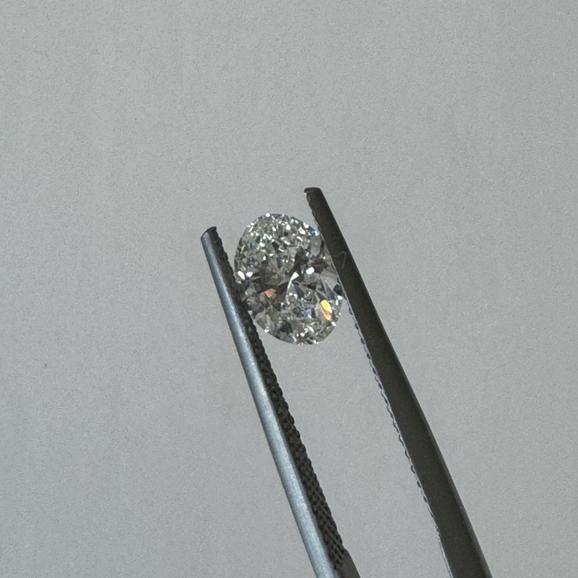 Oval diamond held in tweezers