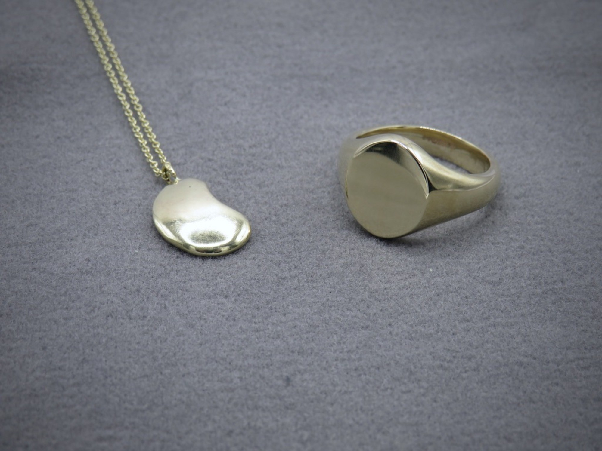 Signet ring and bean pendant in yellow gold