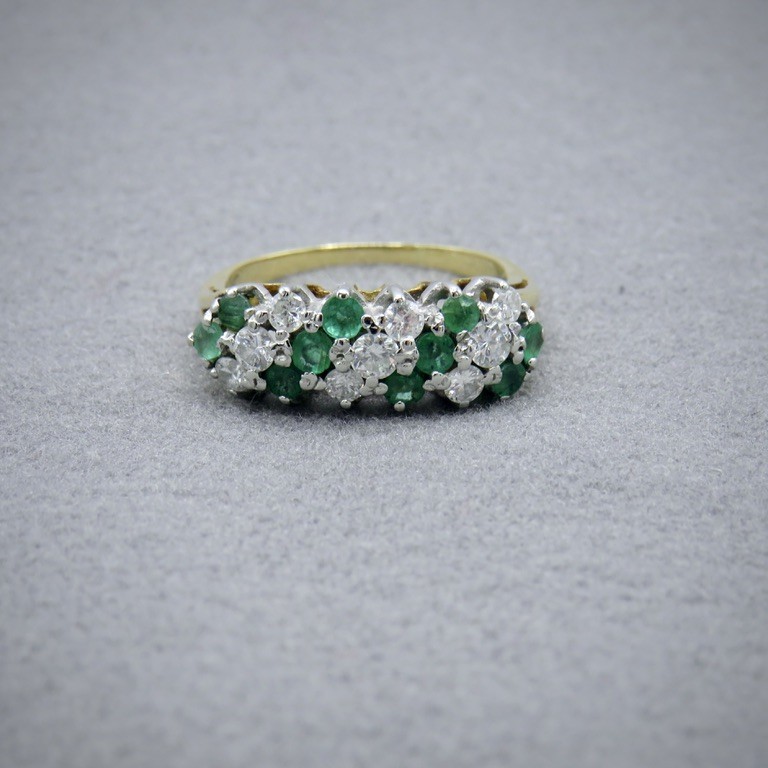 A diamond and emerald ring in a slanting pattern